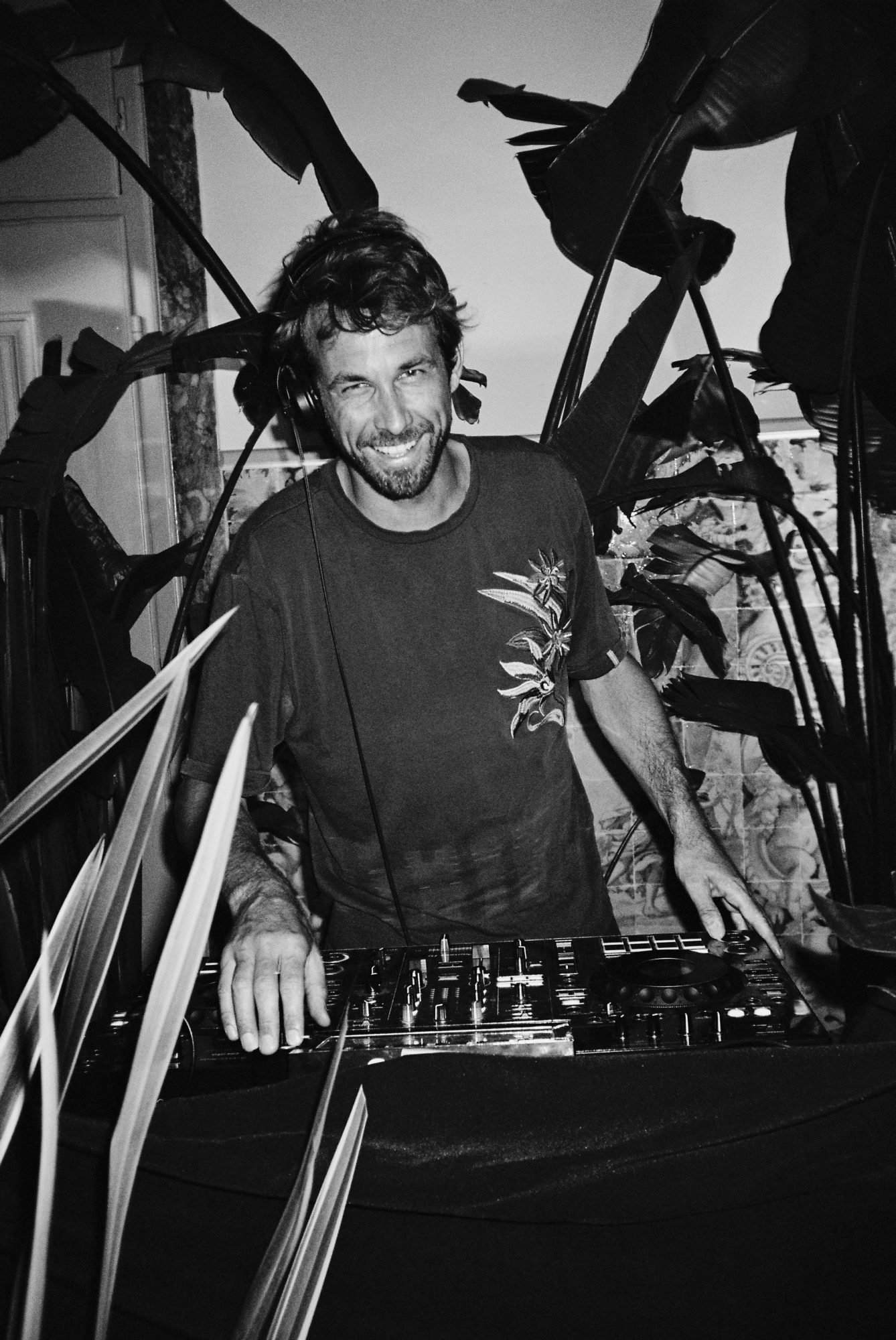 Black and white photo of Space Kadett smiling behind the decks