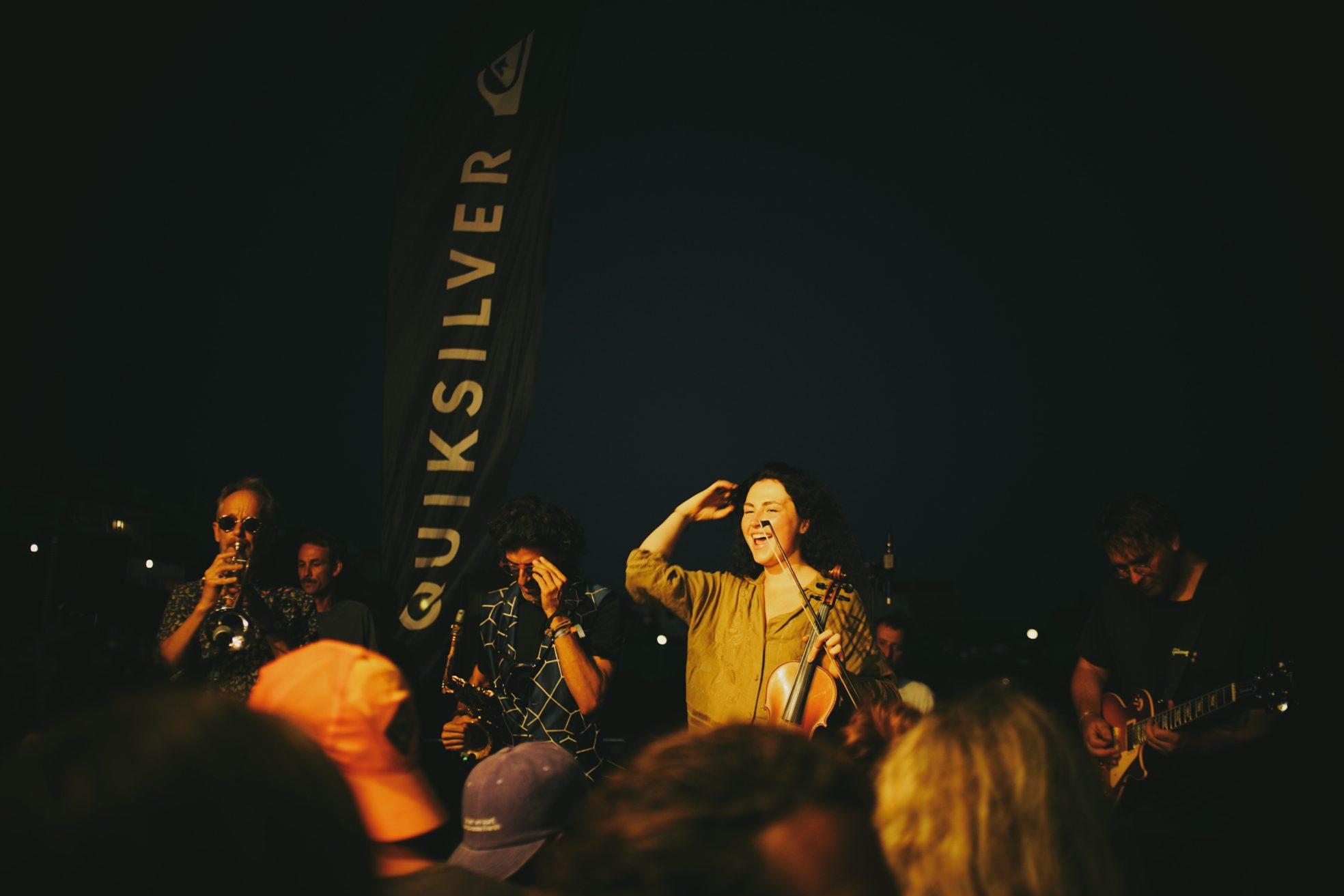 NEW LIVE playing on stage at night, a laughing violinist in the middle
